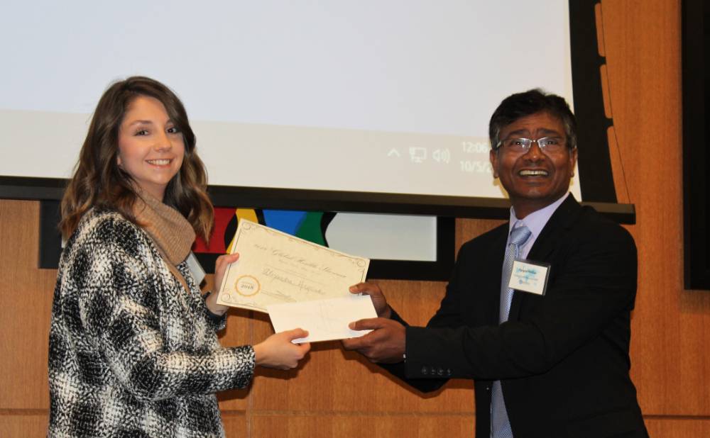 Image 1 of 15 Dr. Molla and the winner of the people&#x27;s choice poster award shaking hands, smiling